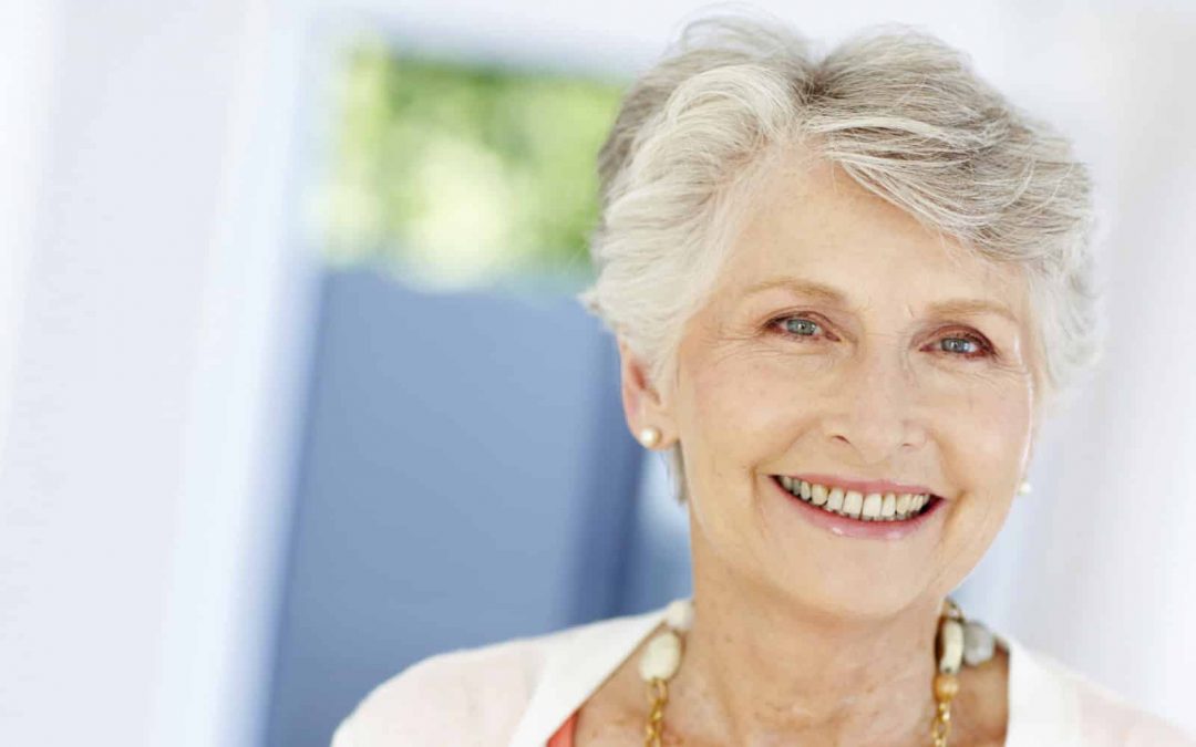 older woman smiling dentures dental implants